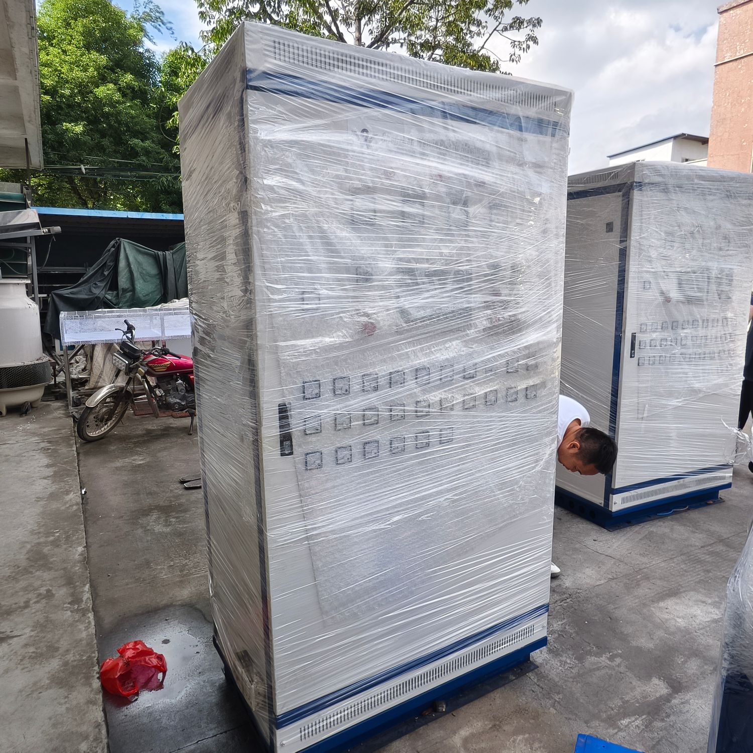Electrical control cabinets wrapped in stretch film and staged for loading