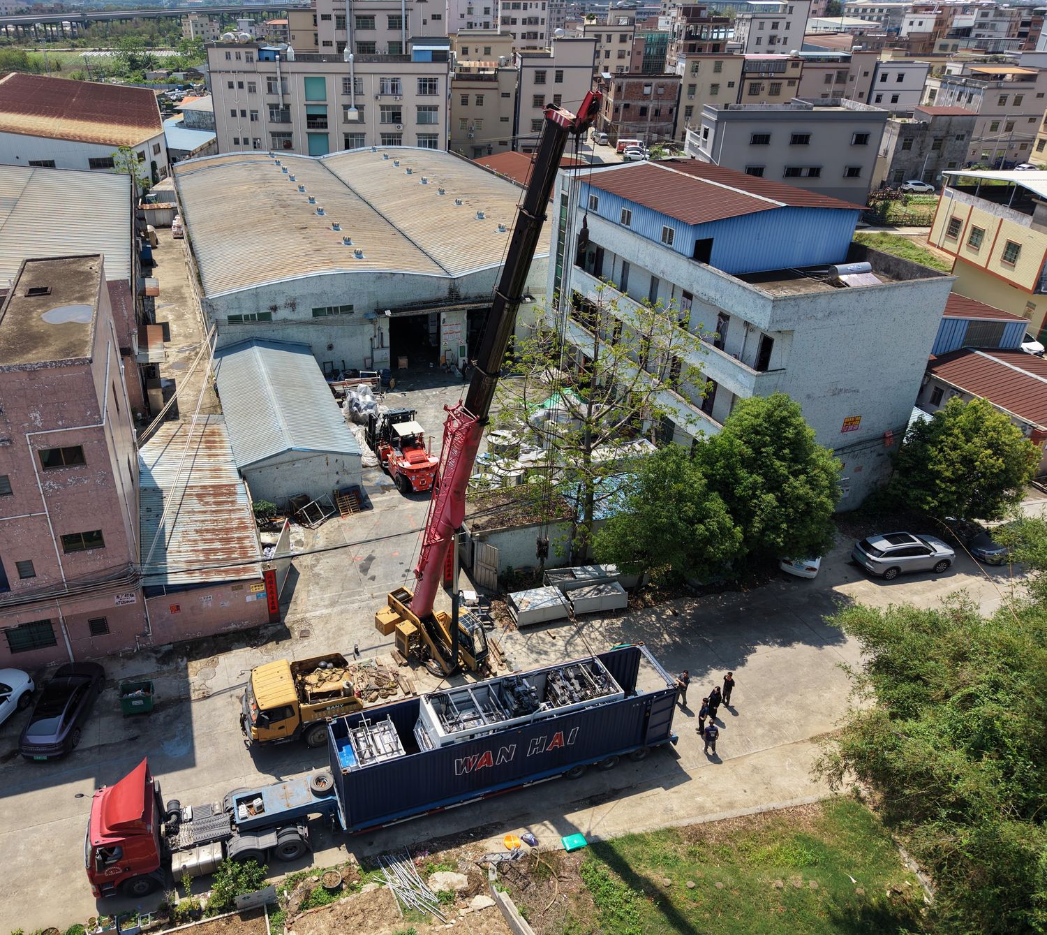 Container loading day seen from above: mobile crane, forklift and container truck in the loading yard